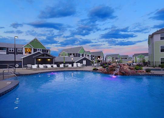 A swimming pool in front of a building with a green roof.