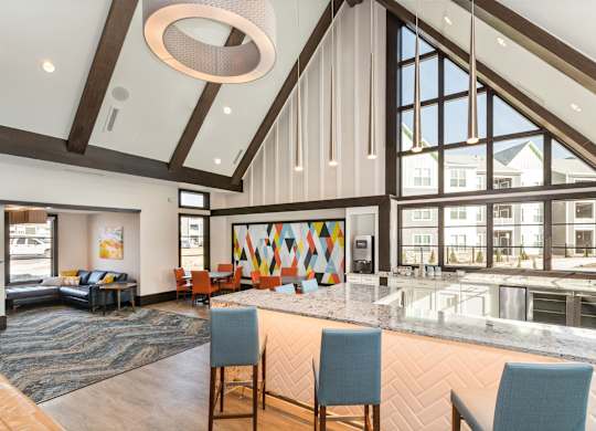 A large, modern room with a high ceiling and a long table with chairs.