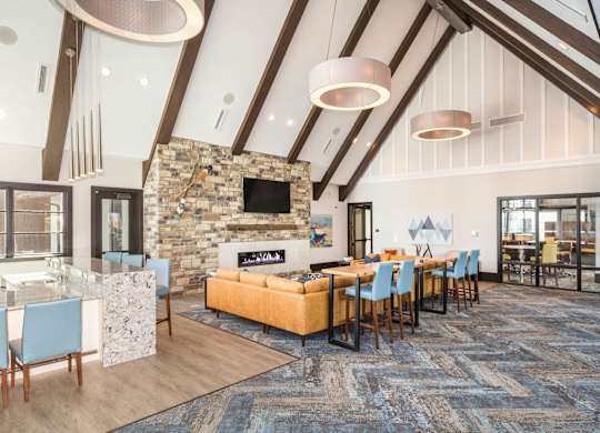 A modern living room with a stone fireplace and a large rug.