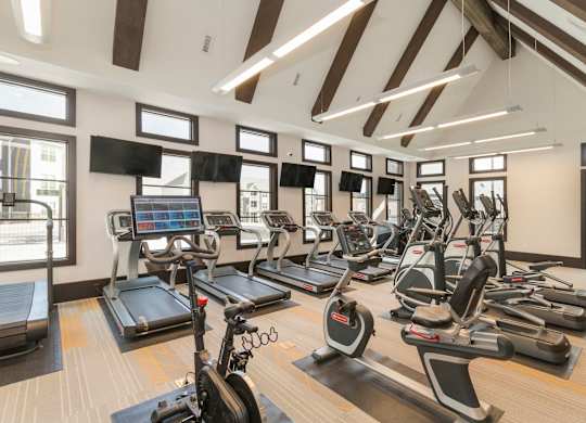 A gym with treadmills, elliptical machines, and other exercise equipment.