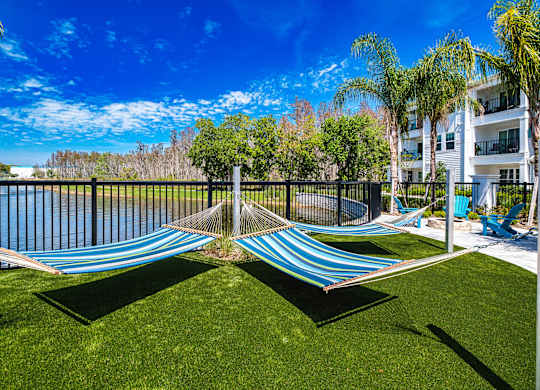 a composite image of a hammock on the grass next to a pool at Altis Grand Suncoast, Land O' Lakes, 34638