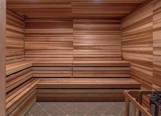 A wooden sauna with benches and a stone floor.