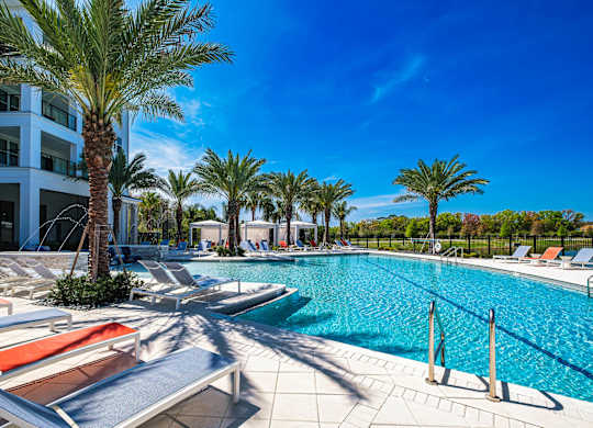 a swimming pool with lounge chairs and palm treesat Altis Grand Suncoast, Florida