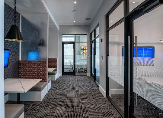 A hallway with a bench, a table, and a glass wall.