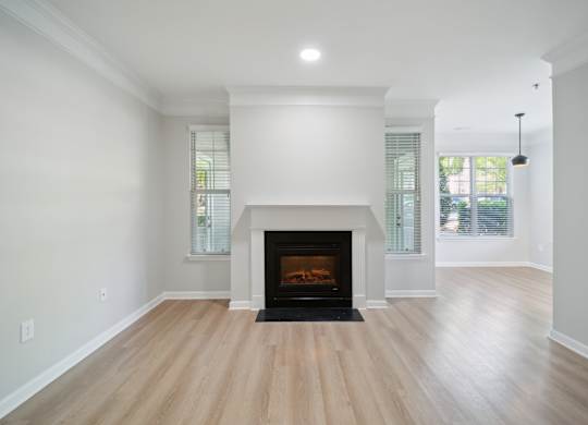 a living room with a fireplace and wooden floors