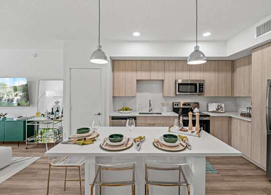 A modern kitchen with a dining table set for two.
