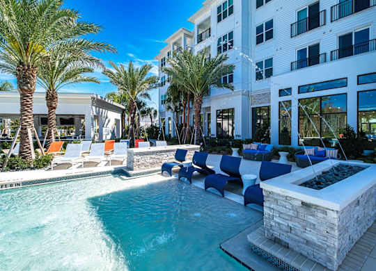 a pool with lounge chairs and a fountain in front of a building at Altis Twin Lakes Apartments, Florida