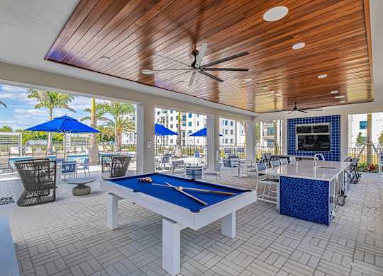 a pool table in a covered patio with tables and chairs at Altis Santa Barbara, Florida