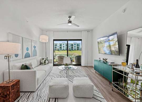 A modern living room with a white sofa, a coffee table, and a television.