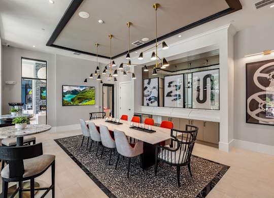 A modern dining room with a glass table and chairs.