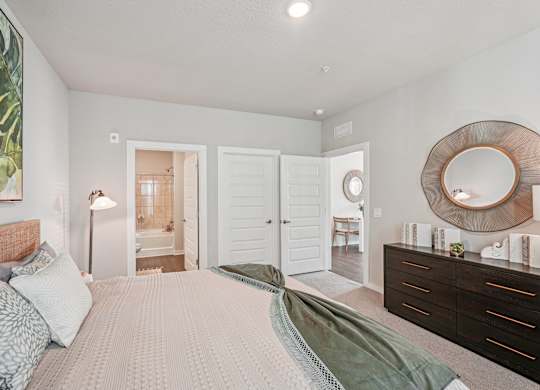 A bedroom with a large bed and a mirror on the wall.