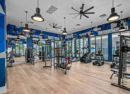 a gym with weights and cardio machines and lights on the ceiling at Altis Santa Barbara, Naples, FL