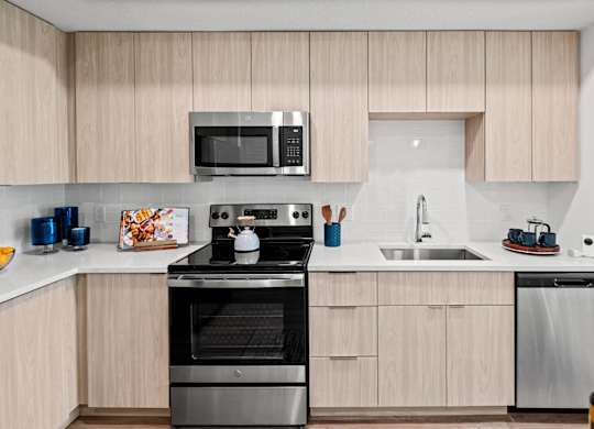 A modern kitchen with wooden cabinets and stainless steel appliances.