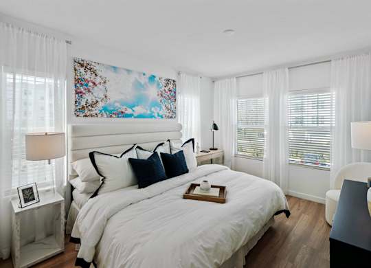 a white bedroom with a large bed and windows at Altis Twin Lakes Apartments, Kissimmee, FL 34744