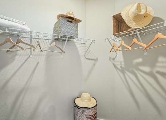 A wall-mounted clothing rack with hats and a spool of thread.