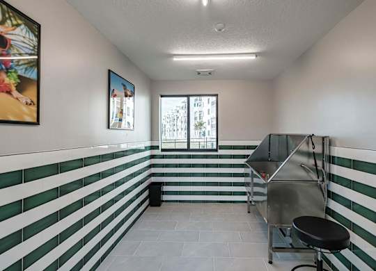 the interior of a room with green and white stripes on the wall and a cart at Altis Santa Barbara, Naples, Florida