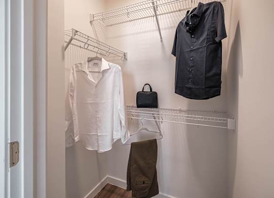a walk in closet with a shirt and jacket hanging on a rack at Altis Twin Lakes Apartments, Kissimmee, FL 34744