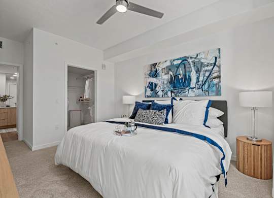 A bedroom with a large bed and a painting on the wall.