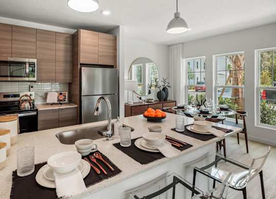 A modern kitchen with a large island and a view of the backyard.