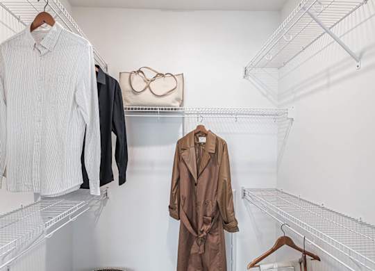 a walk in closet with coats and jackets hanging on the wall  at Altis Grand Suncoast Apartments, Florida, 34638