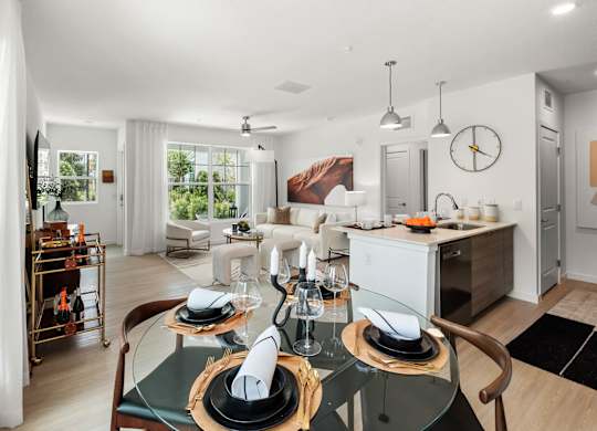A modern dining room with a glass table set for two.