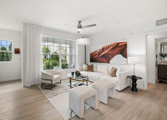 A living room with a white couch, a coffee table, and a painting of a horse on the wall.