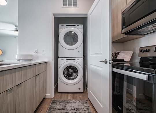 a small laundry room with a washing machine in it at Altis Grand Suncoast, Land O' Lakes, FL