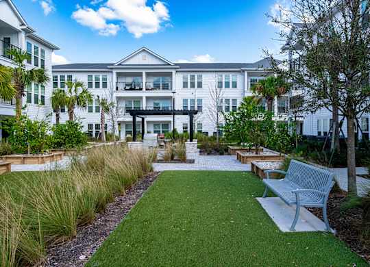 A white building with a green lawn in front.