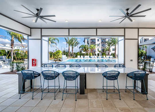 A patio with a bar and chairs overlooking a pool.at Altis Grand Lake Willis, Orlando