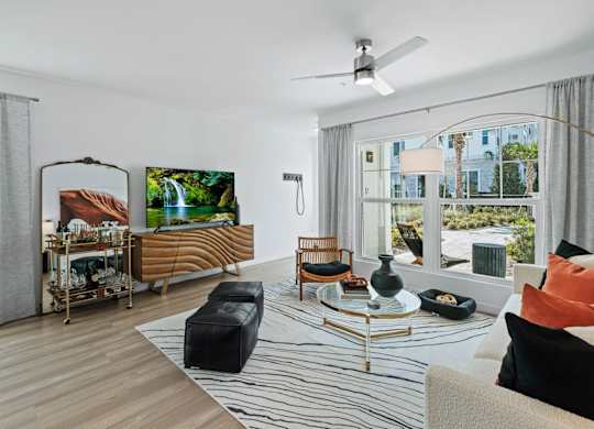 a living room with a couch and a table and a large window at Altis Twin Lakes Apartments, Kissimmee, FL 34744