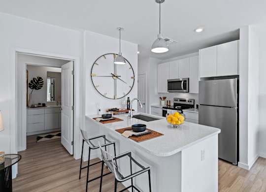 an open kitchen with a large clock on the wall at Altis Grand Suncoast, Land O' Lakes, FL