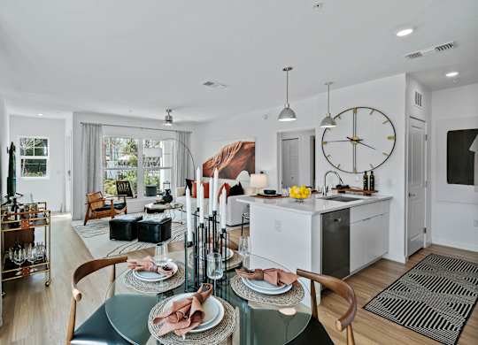 a living room and kitchen with a large clock on the wall at Altis Grand Suncoast, Florida