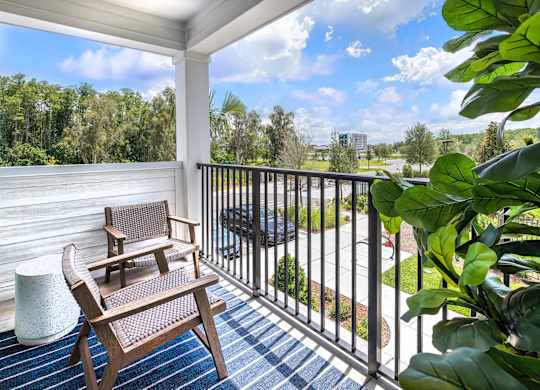 A wooden chair is on a porch with a view of the street.