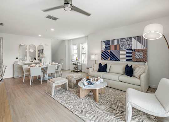 A living room with a white couch, a coffee table, and a large abstract painting on the wall.