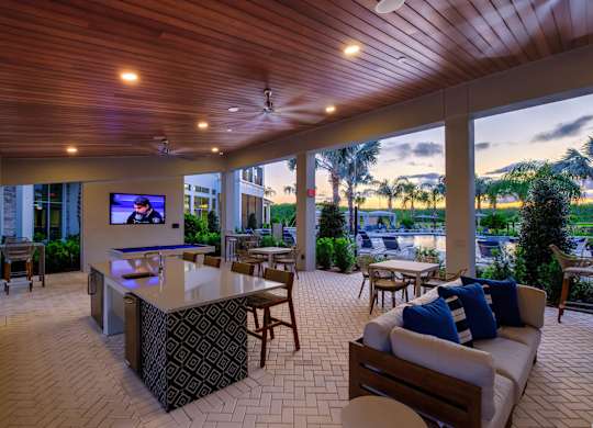 A modern outdoor living space with a bar and seating area.