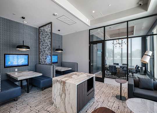 a lobby with couches and tables and a tv at Altis Santa Barbara, Florida, 34104