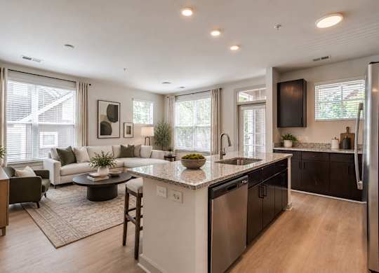 A modern kitchen with a large island and a dining area with a table and chairs.
