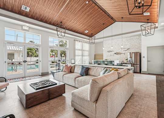 A living room with a wooden ceiling and a large window.