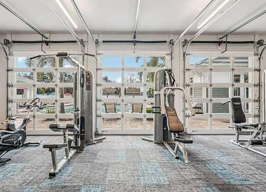 A gym with a variety of equipment including treadmills, stationary bikes, and weight machines.