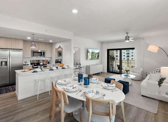 a living room and kitchen with a table and chairs at Altis Santa Barbara, Naples, 34104