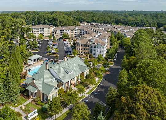 A bird's eye view of a resort with a swimming pool and a large building.