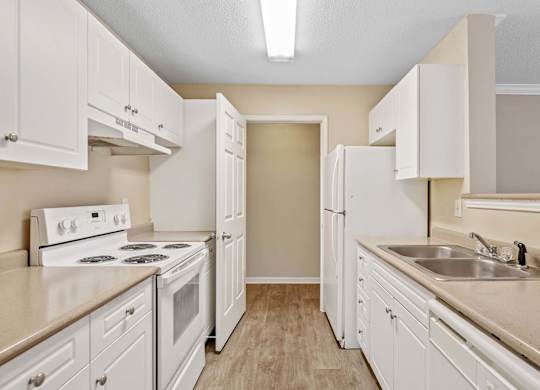 A kitchen with white cabinets and appliances.
