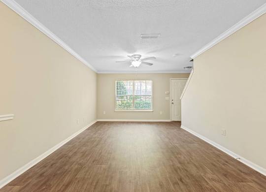 A room with wooden flooring and a ceiling fan.