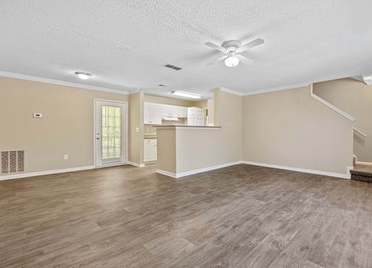 A spacious room with a ceiling fan and lighting fixtures.
