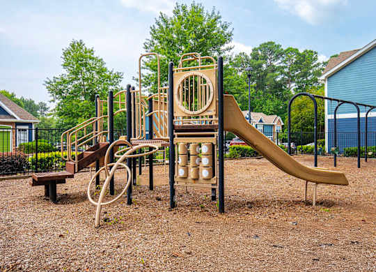 A playground with a slide, swings, and a monkey bars.
