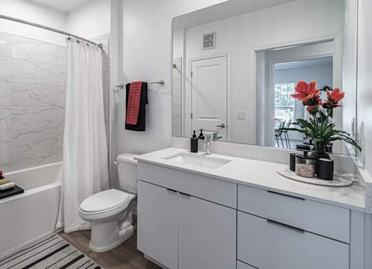 a bathroom with a shower and a sink and a toilet at Altis Grand Lake Willis, Orlando