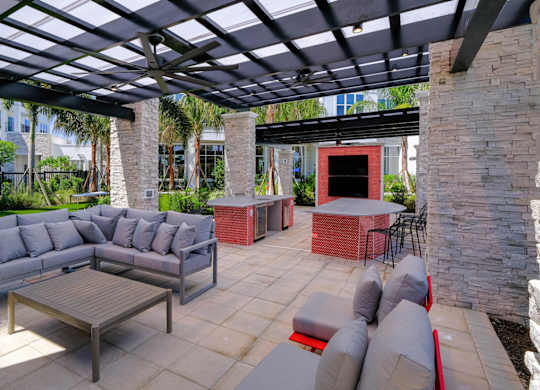 a patio with couches and tables under a pergola at Altis Grand Lake Willis, Florida