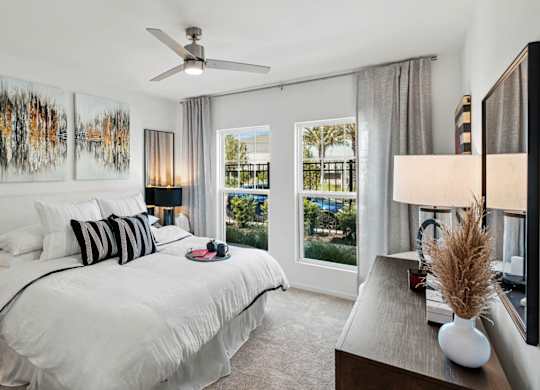a bedroom with a large bed and a ceiling fan at Altis Grand Lake Willis, Orlando Florida