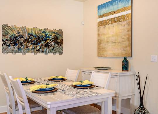 A dining room with a white table set for four.