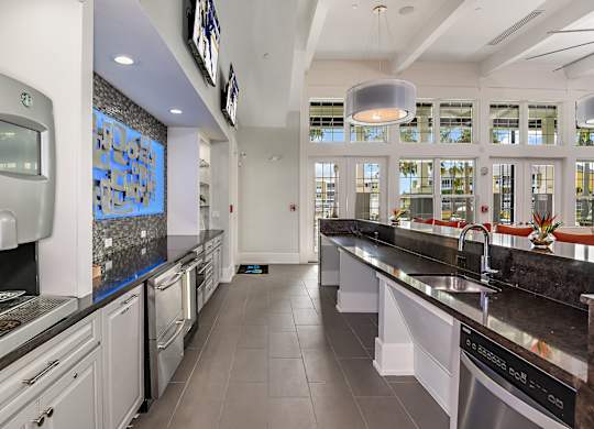 A modern kitchen with a long counter and a dishwasher.